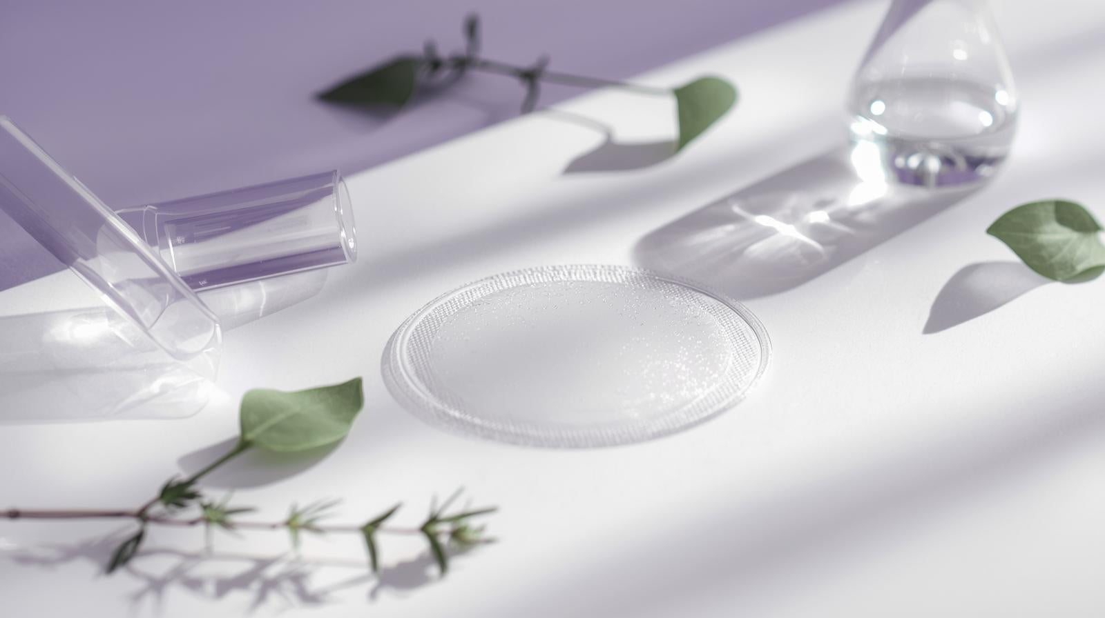 Thin translucent patch on a white surface with natural and scientific elements in background